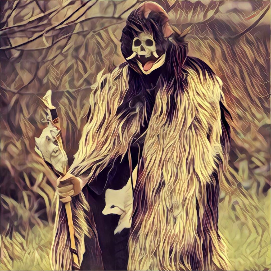 A man dressed in a fur cloack and goat skull mask